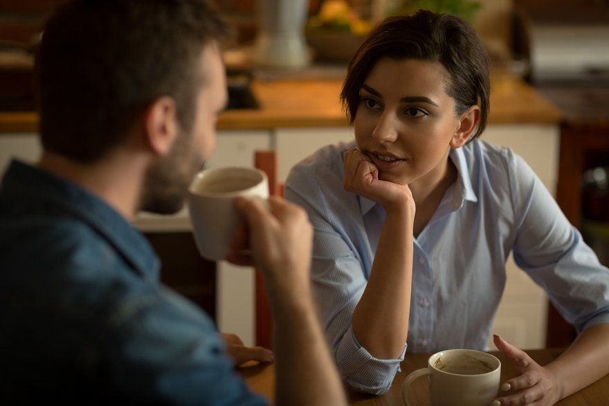 Two people in a relaxed one-to-one conversation over coffee